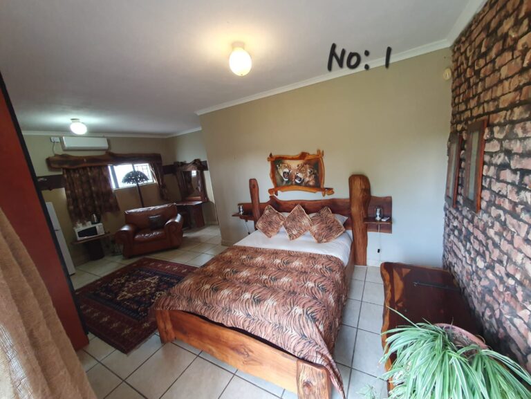 Rooms Rustic wooden double bed with tiger-print bedding in Room 1 at Pecan Guesthouse, Christiana.